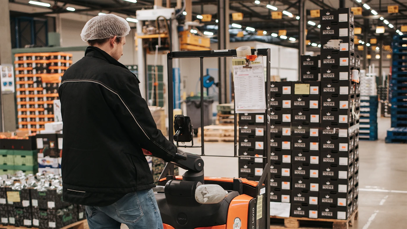 EPT order picker transporting pallets with an electric pallet truck in a warehouse.