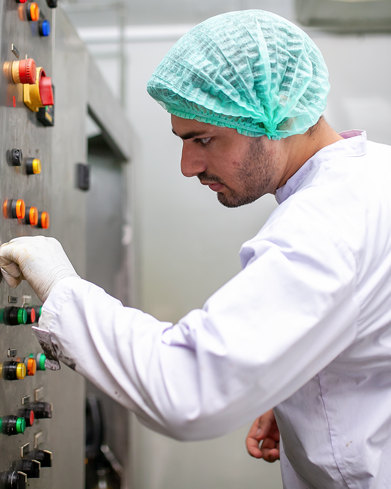 AGF machine operator adjusting machine settings in a large, clean production hall.