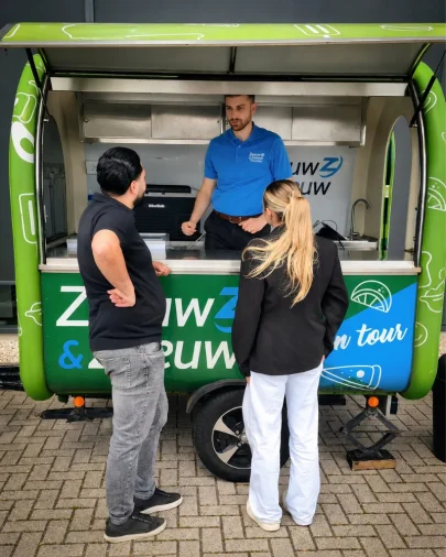 Medewerkers van Zeeuw & Zeeuw serveren ijs tijdens de viering van de 50.000e Kia